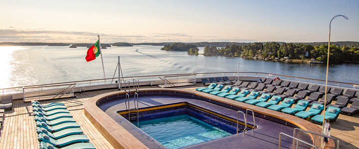 Der Poolbereich am Heck der Vasco da Gama bietet einen ruhigen Blick über das Wasser. Das Schiff gleitet vorbei an einer sanften Landschaft unter freiem Himmel.
